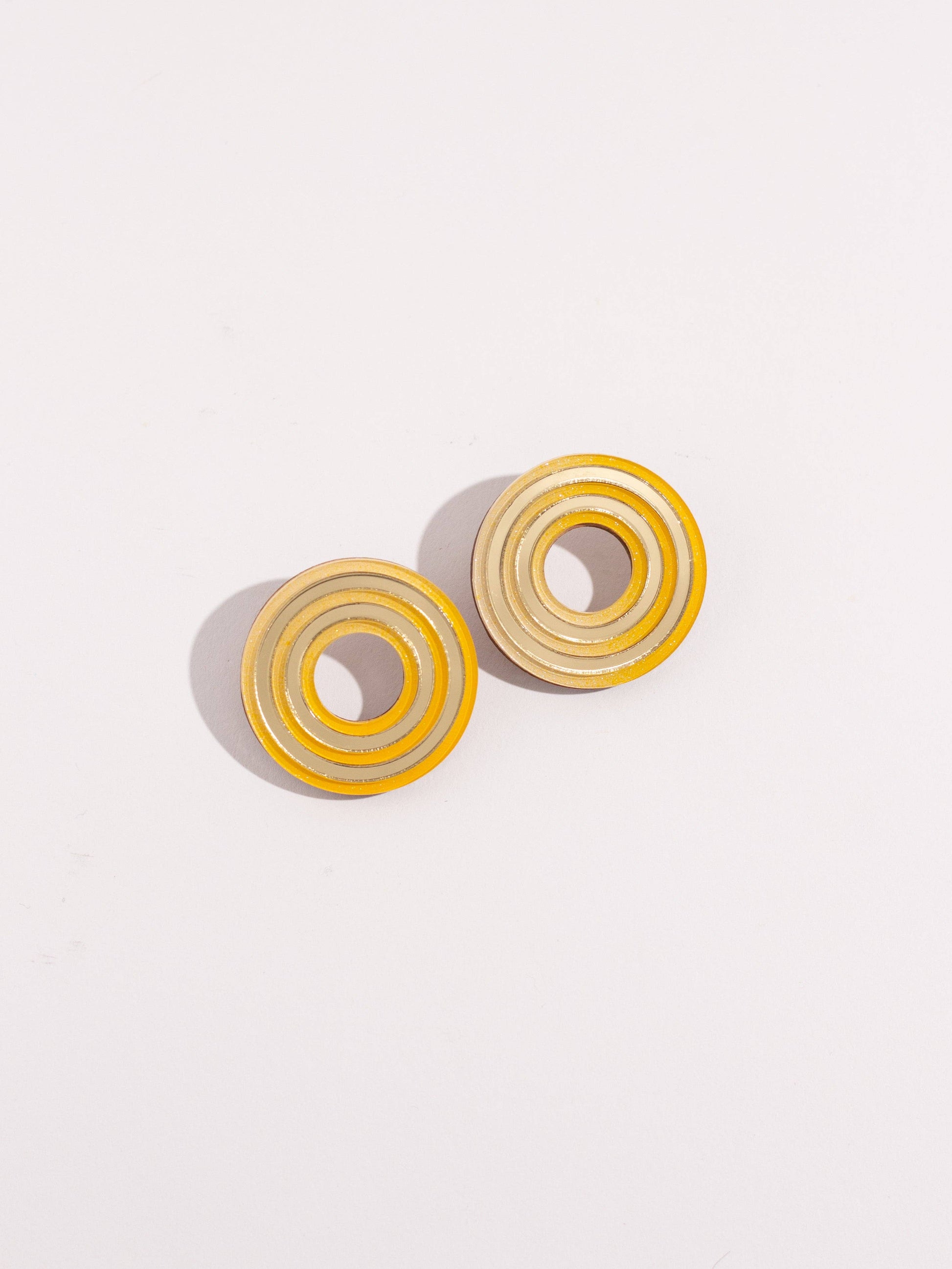 Pair of circular earrings on a light gray background