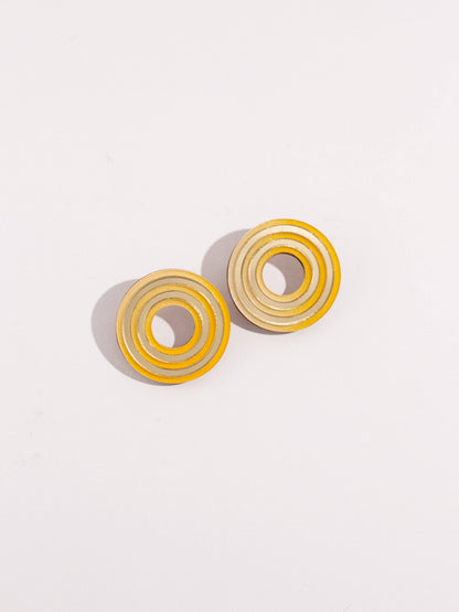Pair of circular earrings on a light gray background
