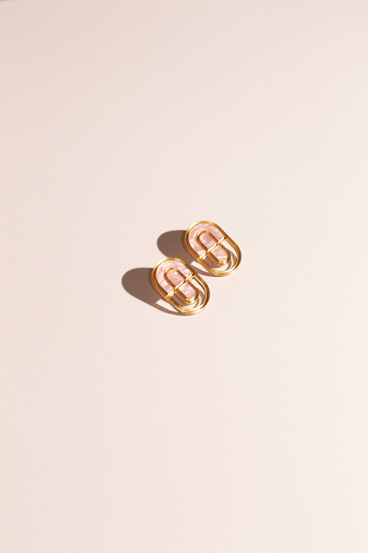 Gold hoop earrings on a beige background