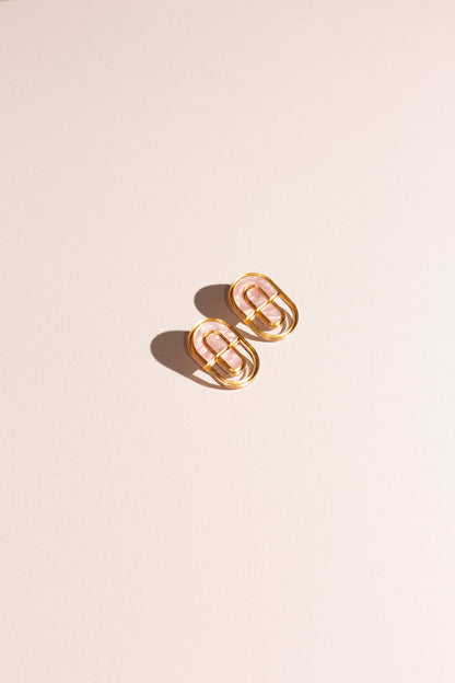 Gold hoop earrings on a beige background
